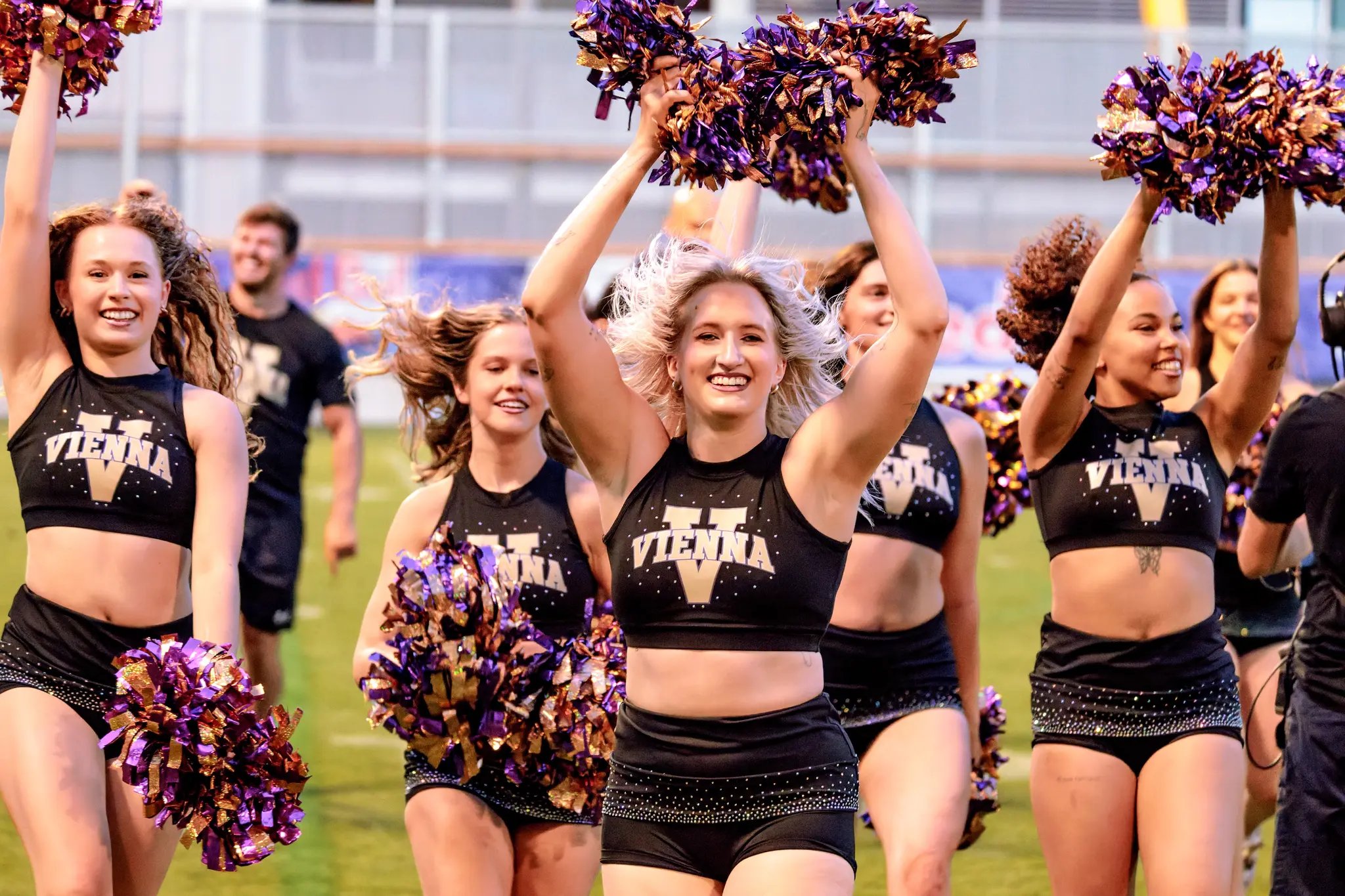 Zurück auf Position: Die Tänzerinnen des Vienna Vikings Spirit Squad kehren nach dem Schlusspfiff mit hochgereckten violett-goldenen Pompoms an ihre Plätze zurück – Abschluss der Cheer-Show.