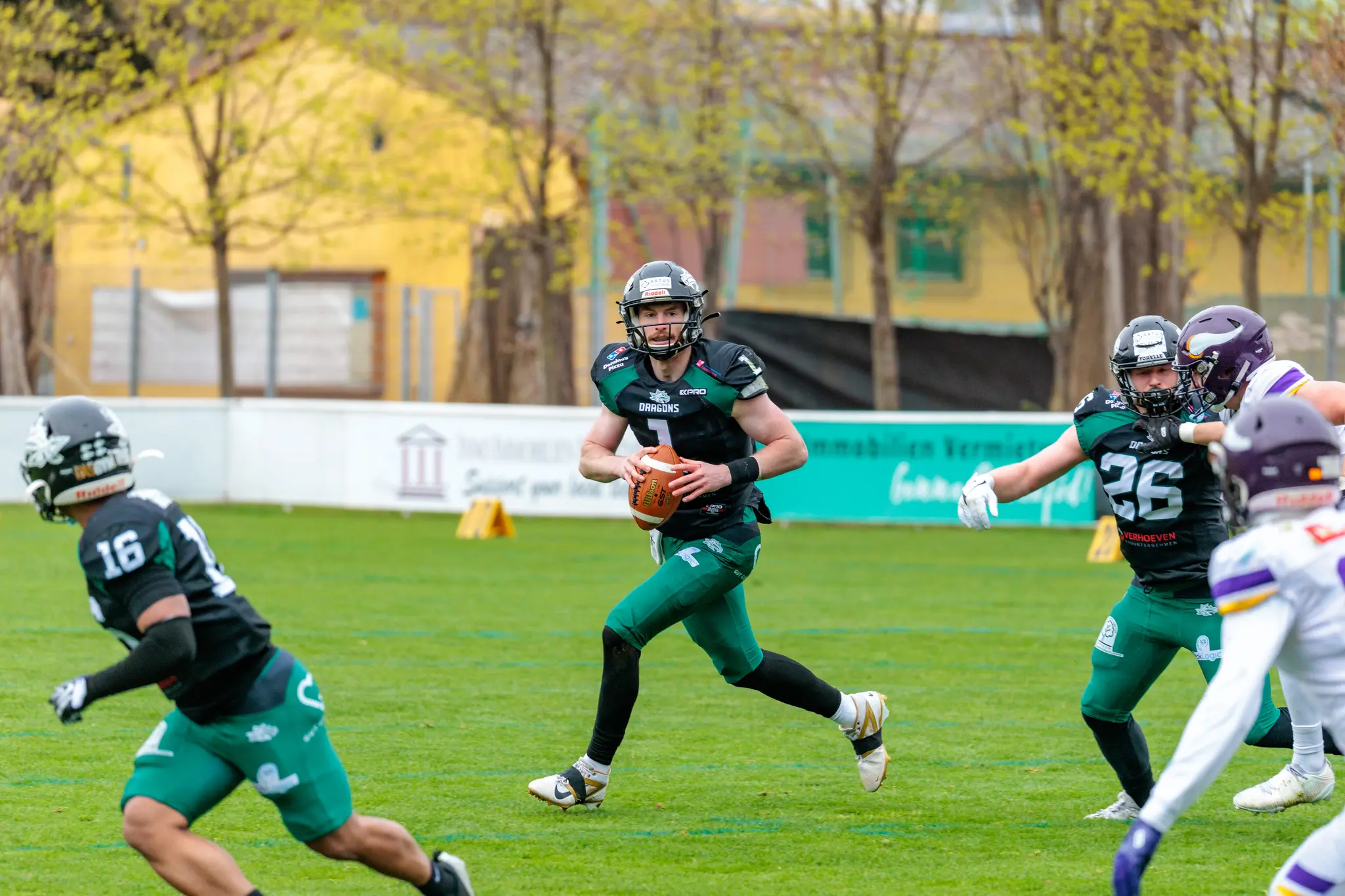 Ein American Football Quarterback der Danube Dragons läuft im Spiel gegen die Vienna Vikings mit dem Ball und sucht eine Anspielstation