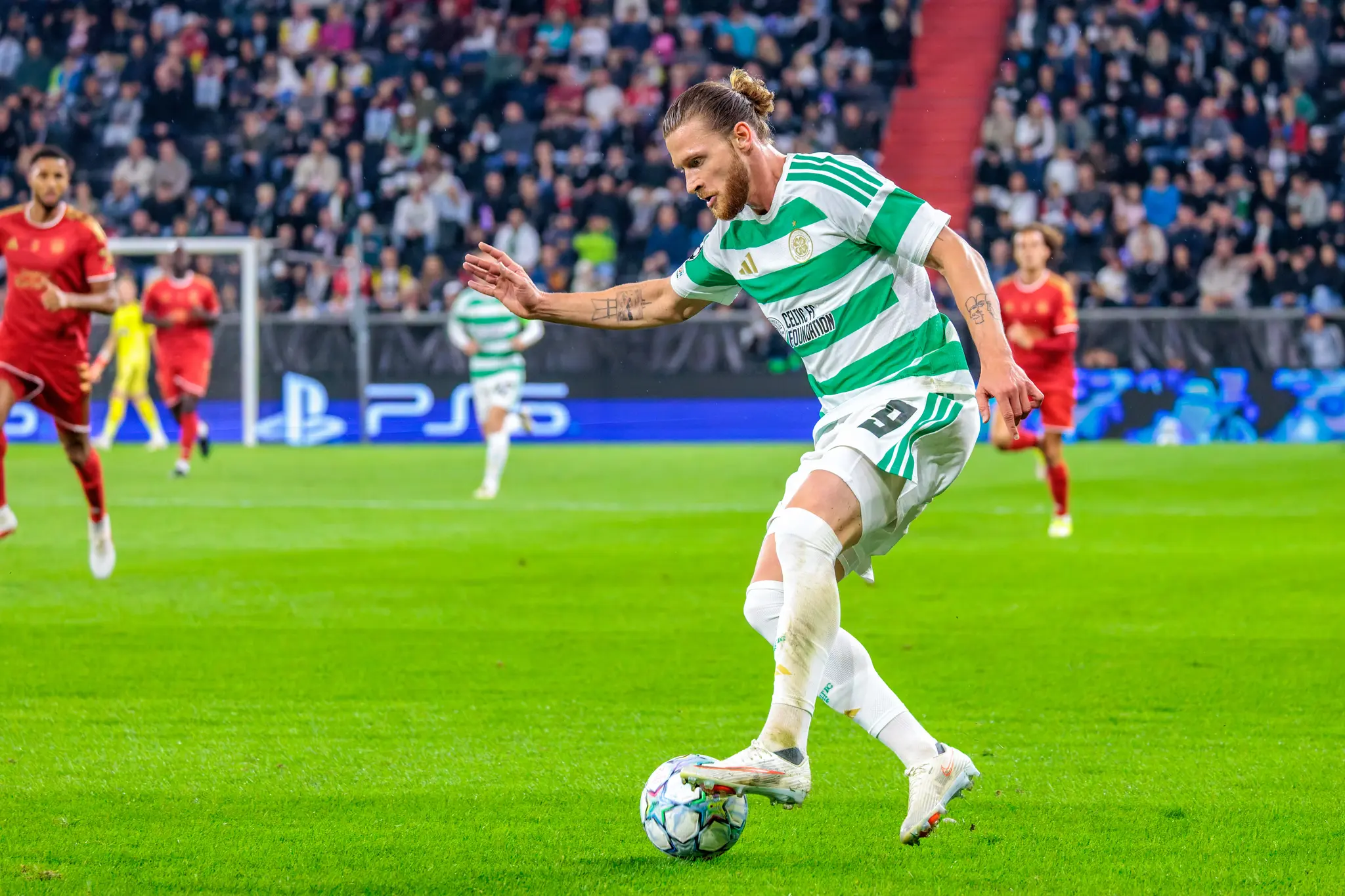 Celtic-Stürmer Kasper Högh tupft den Ball nach vorn und beschleunigt mit viel freiem Raum vor sich.