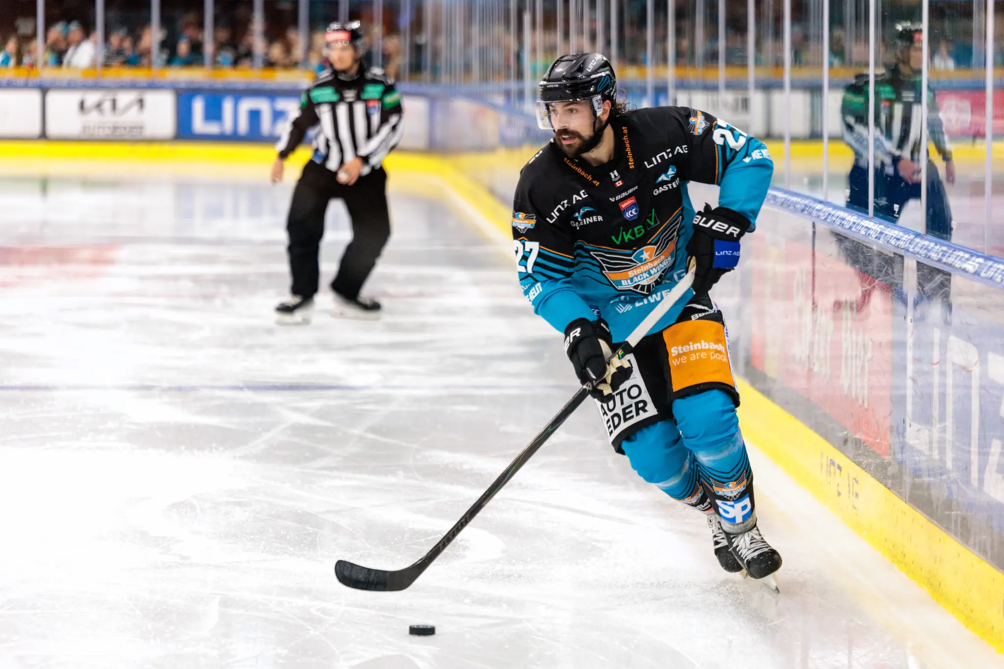 Eishockeyspieler Shawn St-Amant von den Black Wings Linz dribbelt den Puck auf dem Eis während eines Spiels