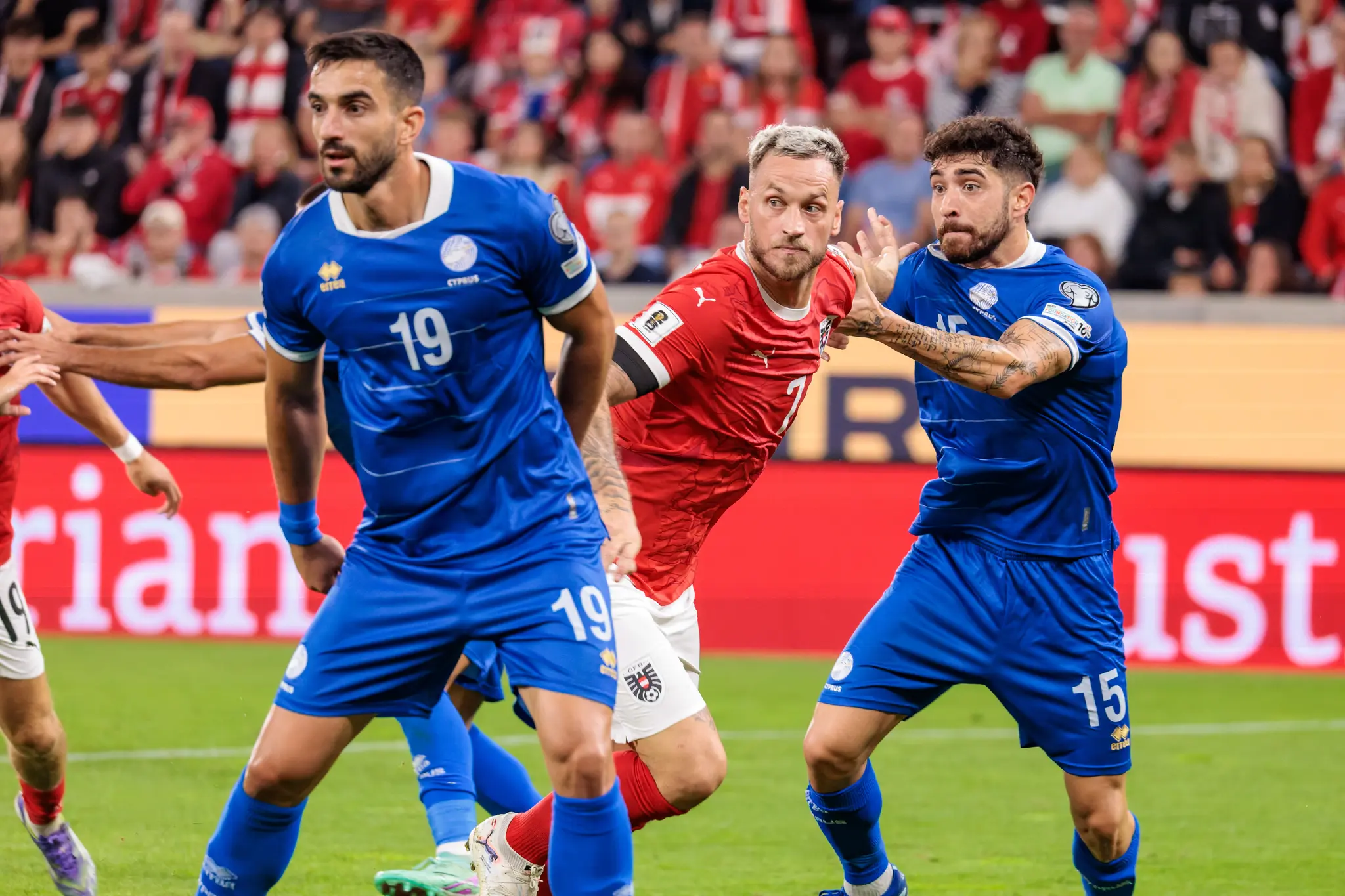 Marko Arnautović im roten Trikot im Zweikampf mit zwei zyprischen Fußballern in blauen Trikots während des WM-Qualifikationsspiels Österreich gegen Zypern