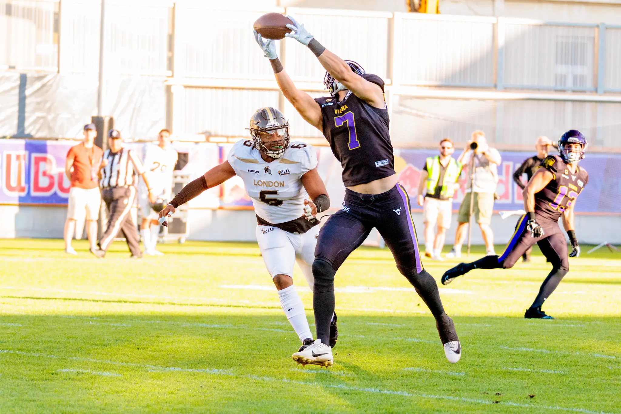 Bernhard Seikovits (7) der Vienna Vikings fängt den Ball am höchsten Punkt, während ihm ein Verteidiger der London Warriors (6) in den Rücken springt – spektakulärer Passfang.