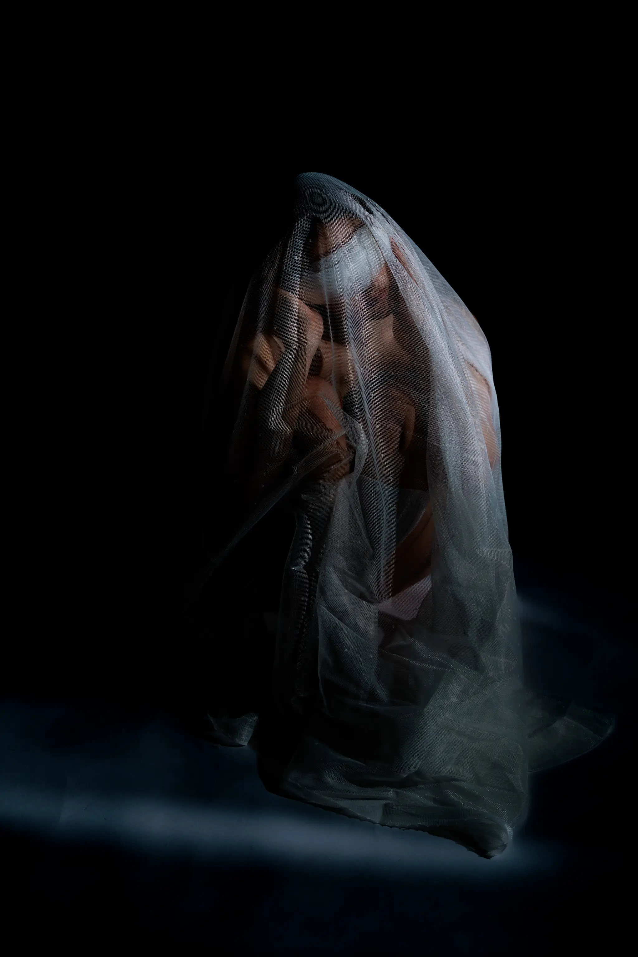 Anja Stiftinger in einer künstlerischen und emotionalen Darstellung unter einem transparenten weißen Schleier vor dunklem Hintergrund