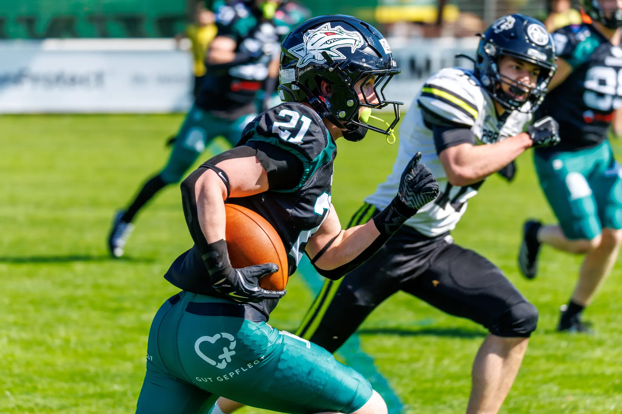 Ein American Football Spieler der Danube Dragons läuft mit dem Ball vor einem verfolgenden Spieler der Prague Black Panthers