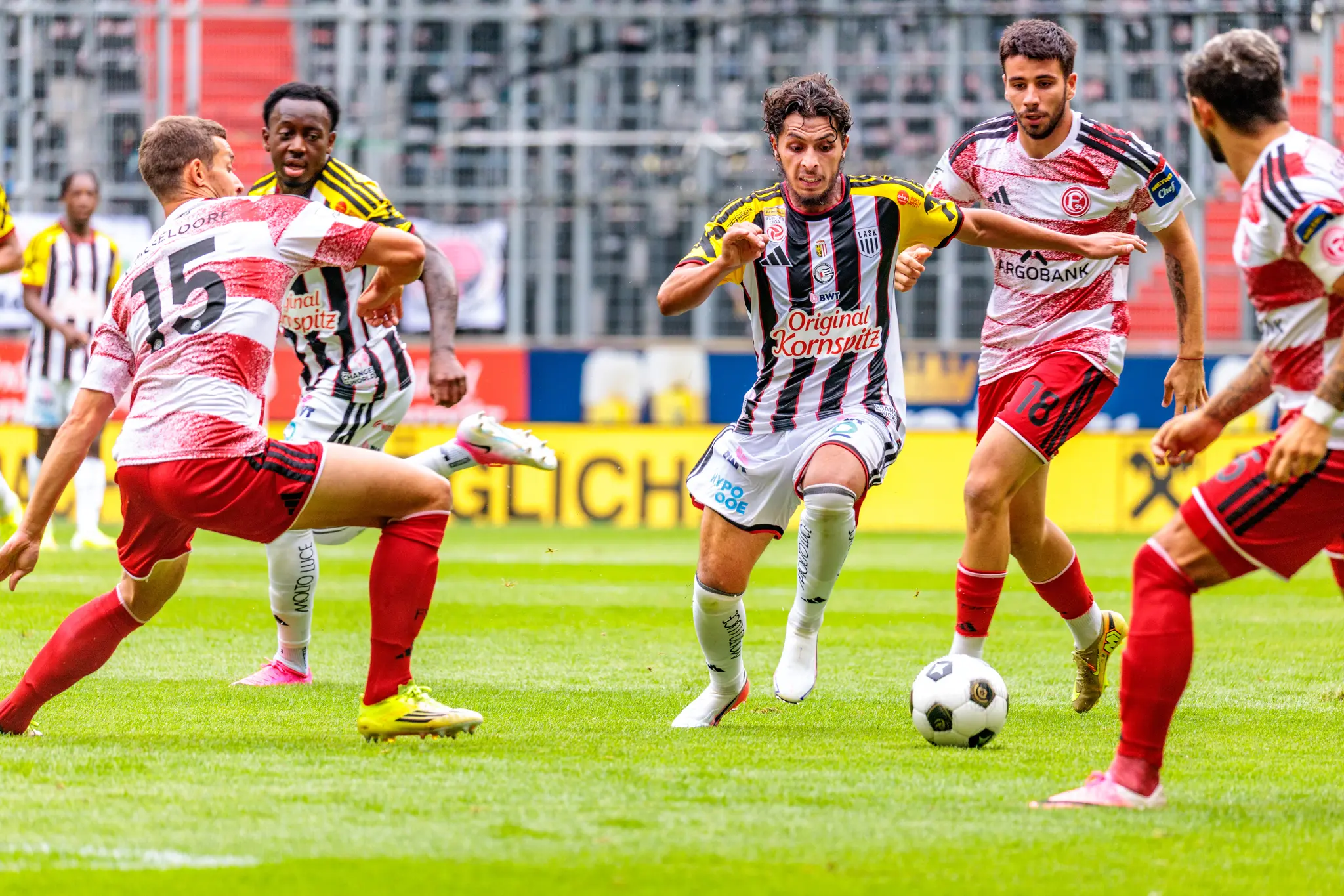 LASK-Mittelfeldspieler mit Ball umringt von vier Düsseldorfer Spielern in der 54. Minute, entscheidende Szene vor dem Führungstor durch Jörgensen.