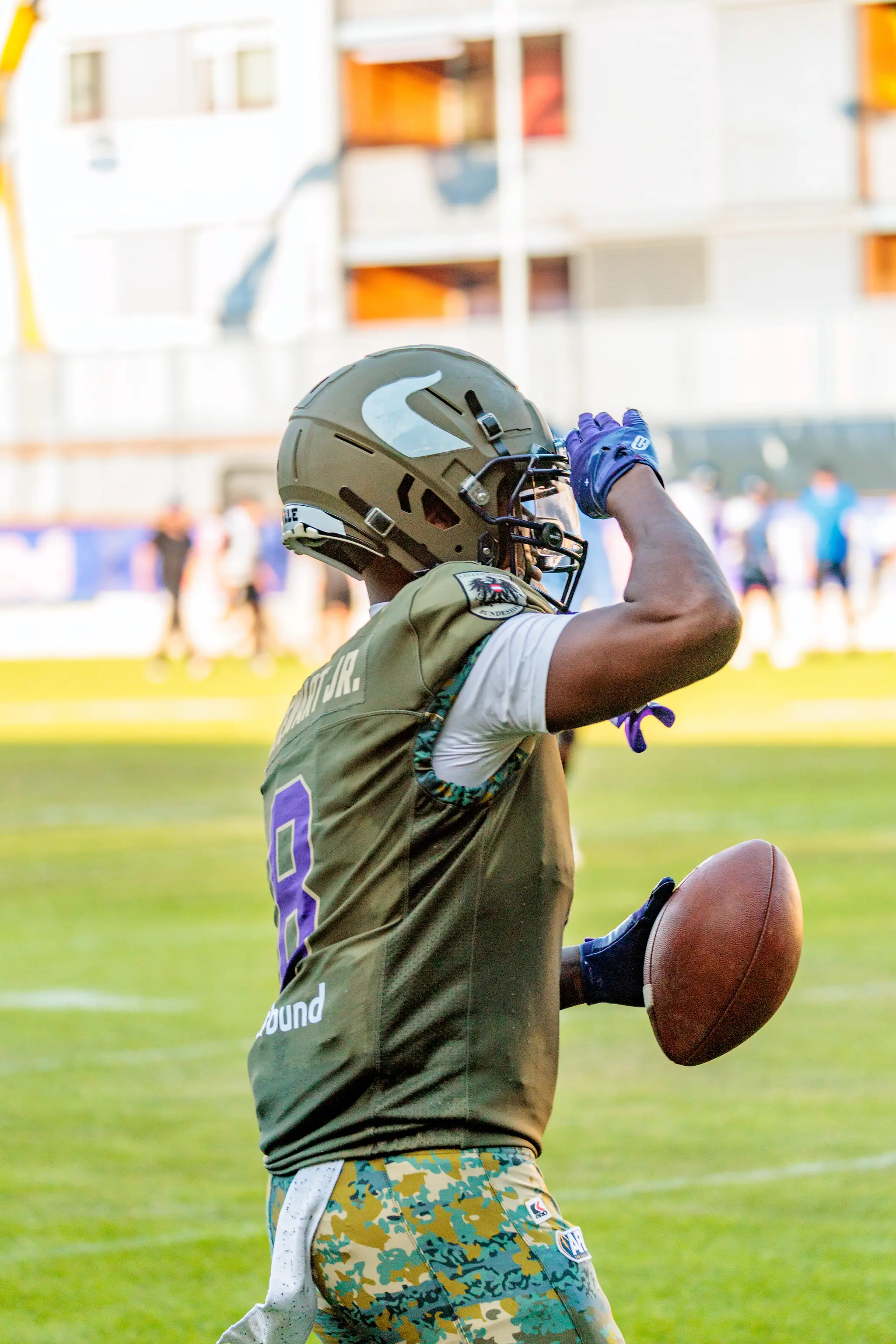 Vikings-Spieler Darrell Stewart Jr. (Nummer 8) salutiert mit der Hand an der Helmseite, den Football in der anderen Hand.