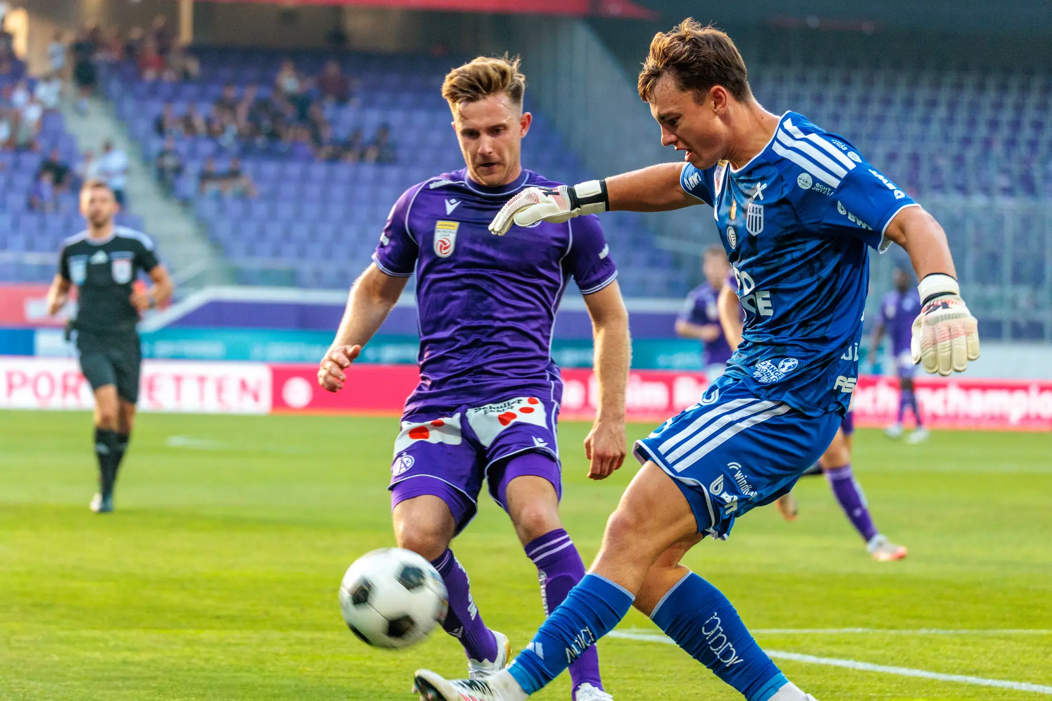 LASK-Torwart Jungwirth kommt weit aus dem Tor und klärt den Ball, ein Austria-Spieler nähert sich