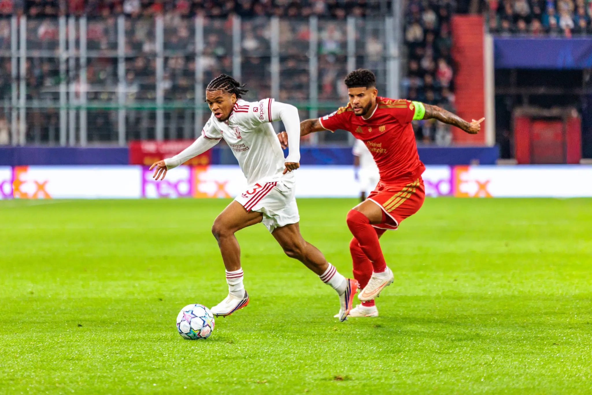 Rio Ngumoha (73) führt den Ball für Liverpool nach außen, LASK-Verteidiger Yvan Dibango (25) läuft schräg hinter ihm.
