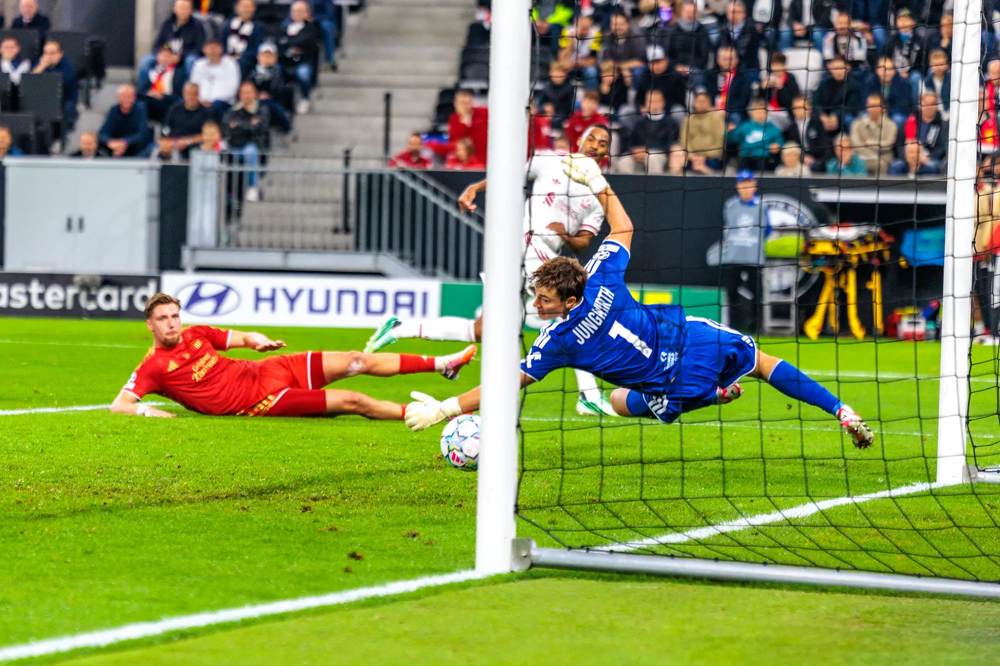 Der Ball ist nach dem Schuss an den Innenpfosten abgeprallt, LASK-Torwart Jungwirth (1) fliegt gestreckt durch die Luft – Schütze ist Ryan Gravenberch (38).