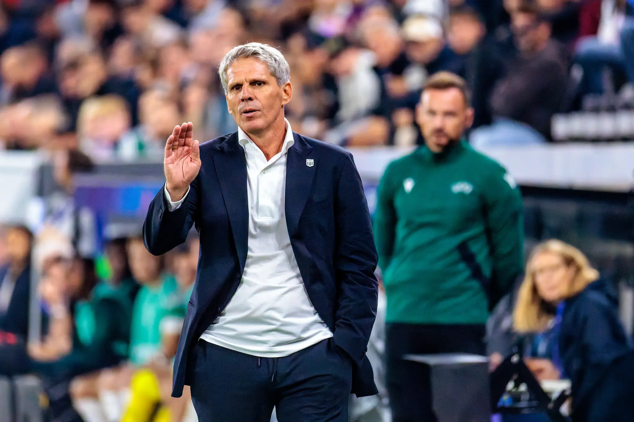 LASK-Trainer Dietmar Kühbauer gestikuliert an der Seitenlinie mit erhobener offener Hand - die Linzer Coaches sehen am Spielfeldrand an der Raiffeisen Arena.