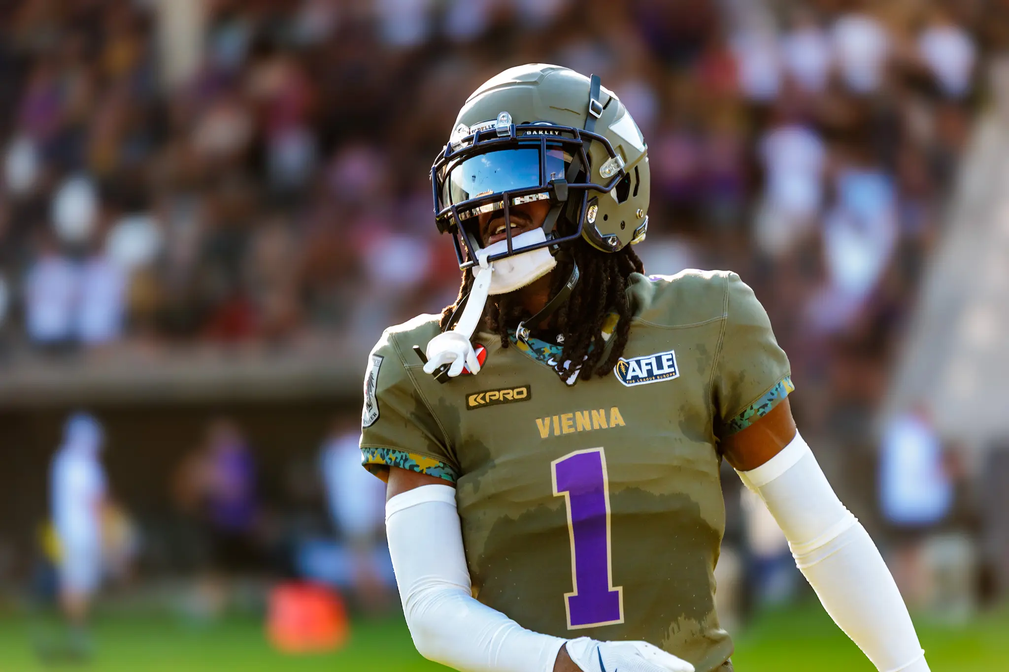 Porträt eines Vienna-Vikings-Spielers mit goldenem Helm und violett-goldenem Trikot vor den Tribünen.
