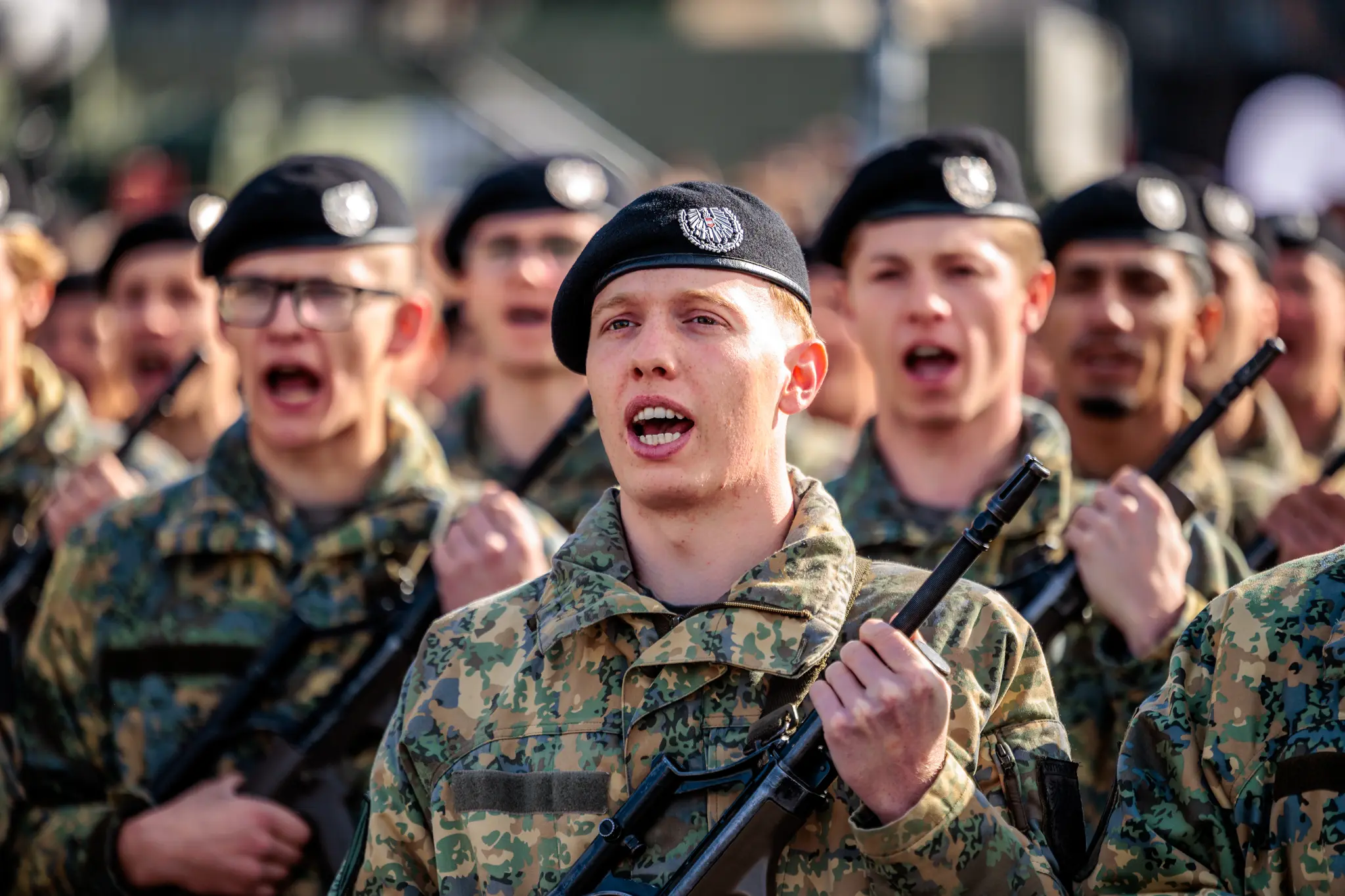 Ein junger Rekrut mit schwarzem Baret und Tarnuniform steht während der Angelobung in der Formation und blickt konzentriert nach vorn.