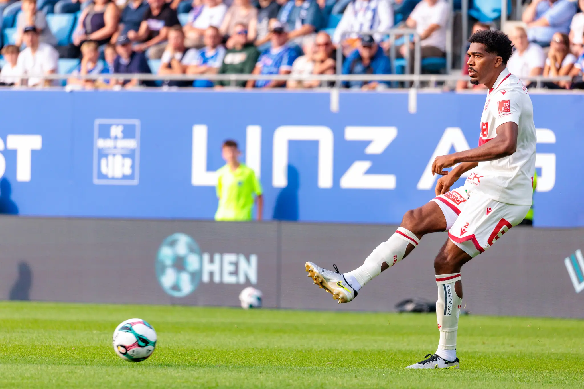 Fußballspieler Donovan Pines vom Grazer AK schlägt in seinem weißen Trikot während eines Bundesliga-Spiels einen Pass