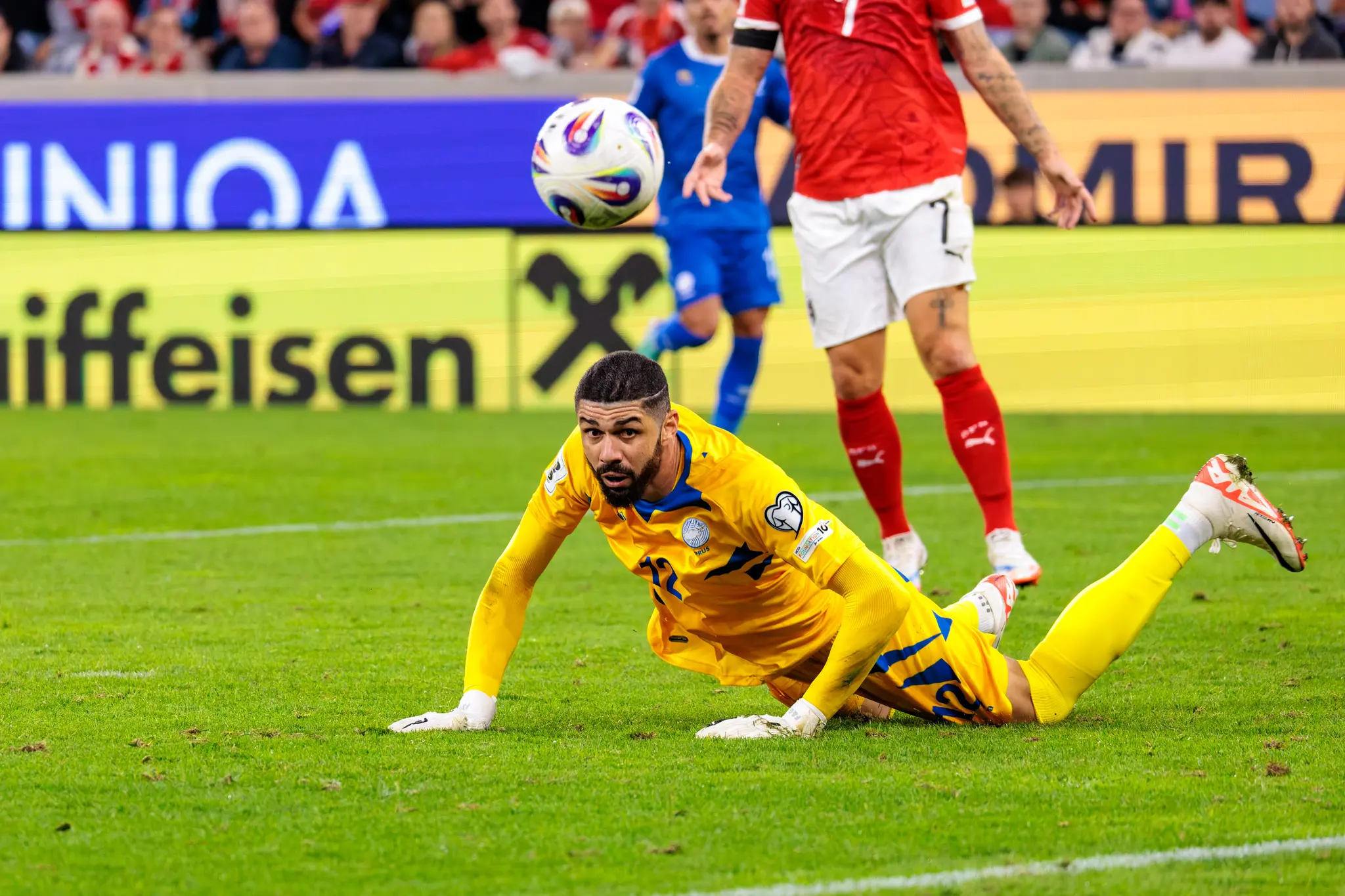 Der zyprische Torwart Fabiano im gelben Trikot liegt nach einer Aktion auf dem Spielfeld und blickt zum Betrachter, während ein Ball über ihm schwebt