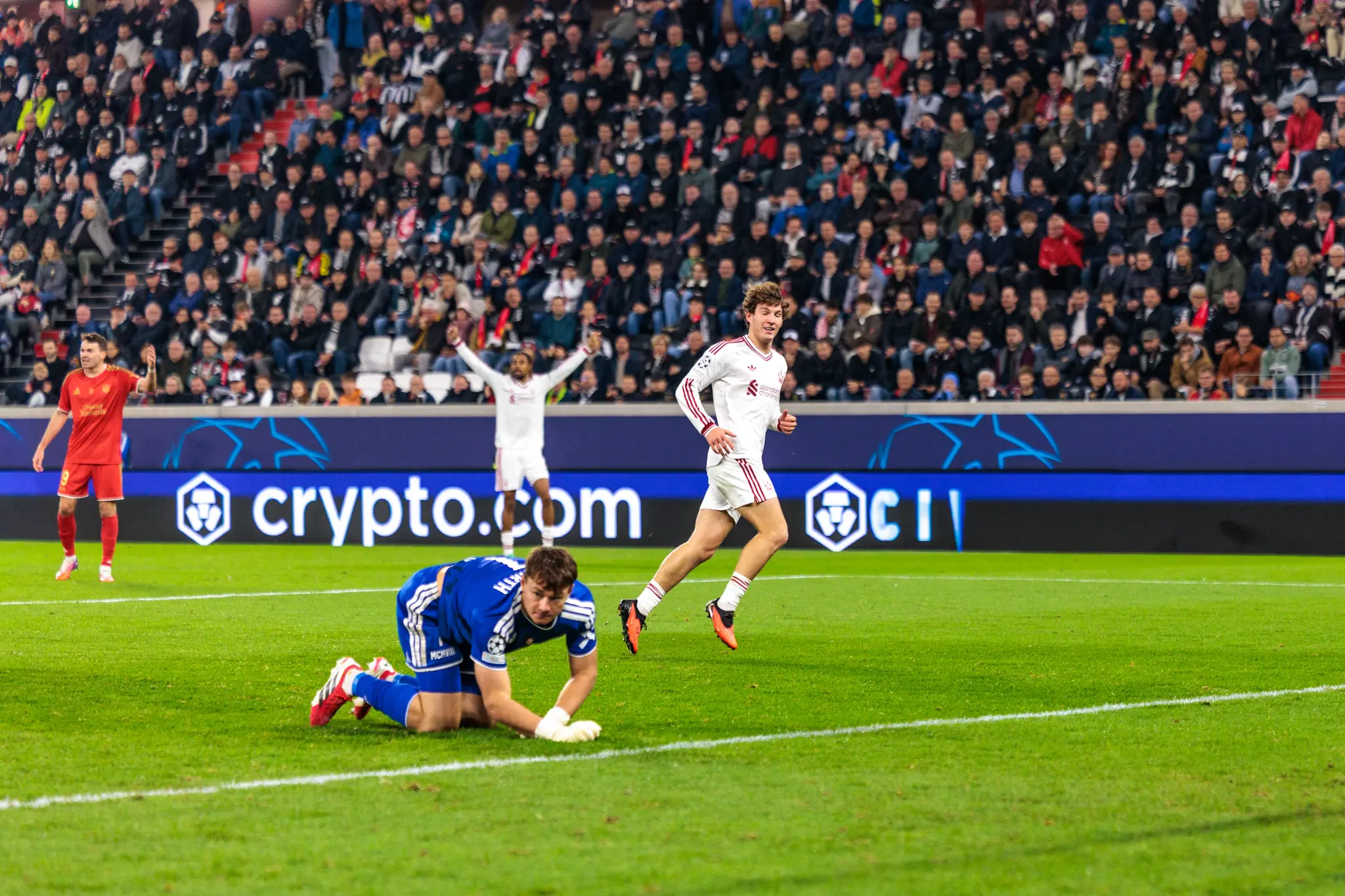 LASK-Torwart Jungwirth (1) kniet am Boden, ein Liverpooler Spieler läuft mit orangen Schuhen vorbei – der Treffer wird wegen Abseits nicht gegeben.