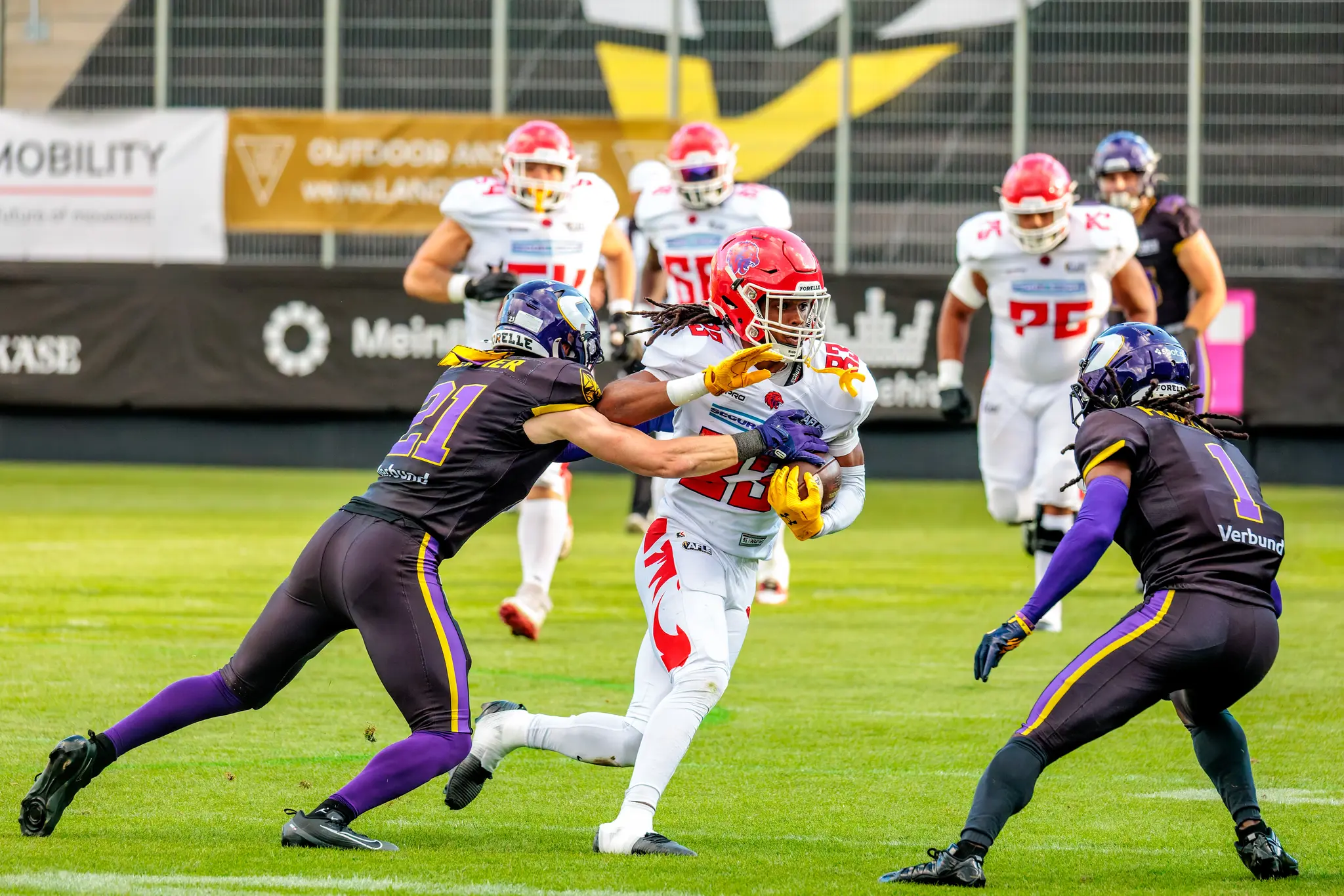 Dicht dran: Red-Lions-Receiver (83) sichert den Ball, doch Leonhard Gerner (21) und Marloshawn Franklin Jr (1) sind sofort zur Stelle – enges Coverage-Duell der Vikings-Defensive.